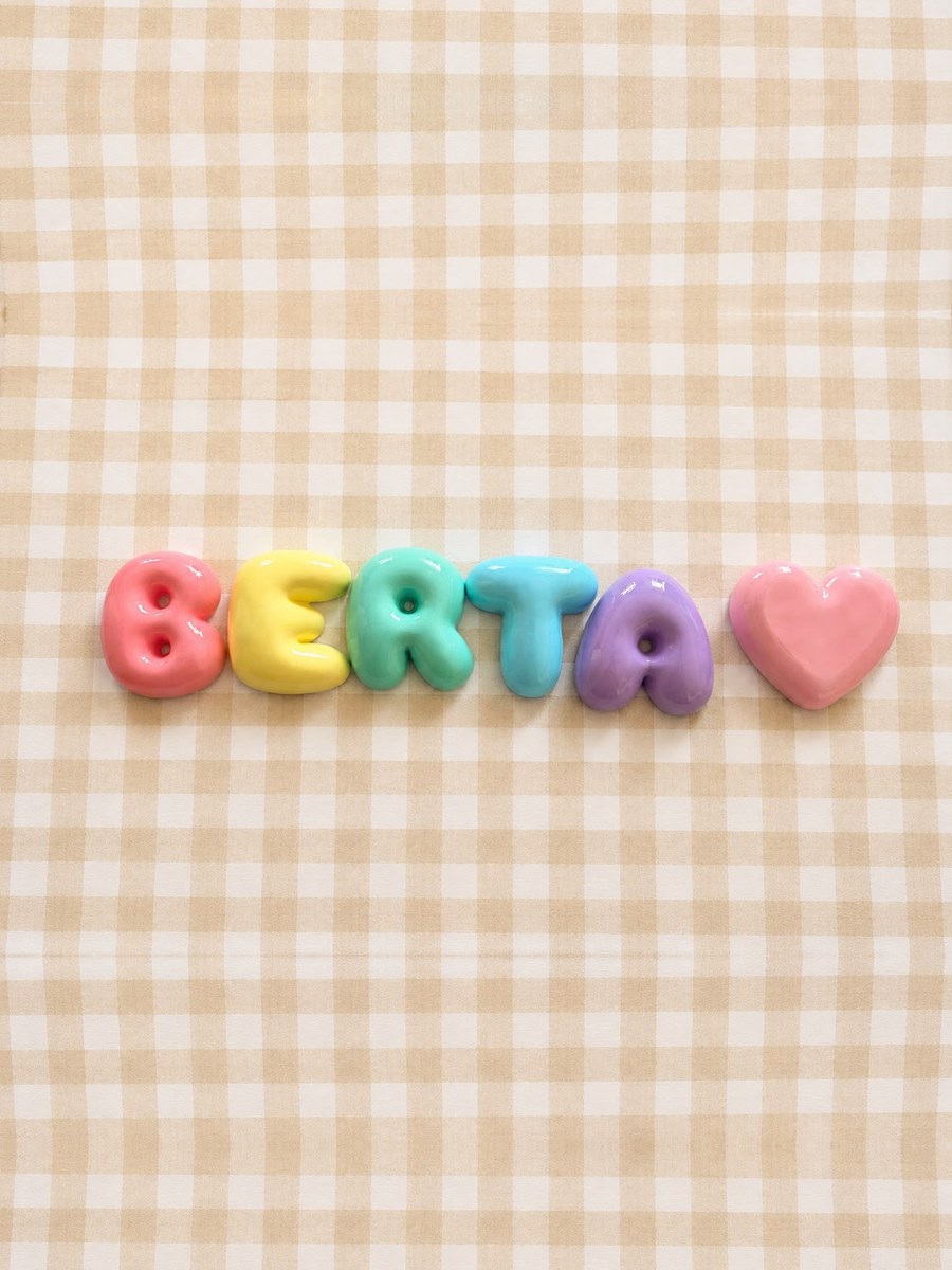 Nombre Berta en letras bubble pastel con un corazón rosa sobre un mantel de cuadros