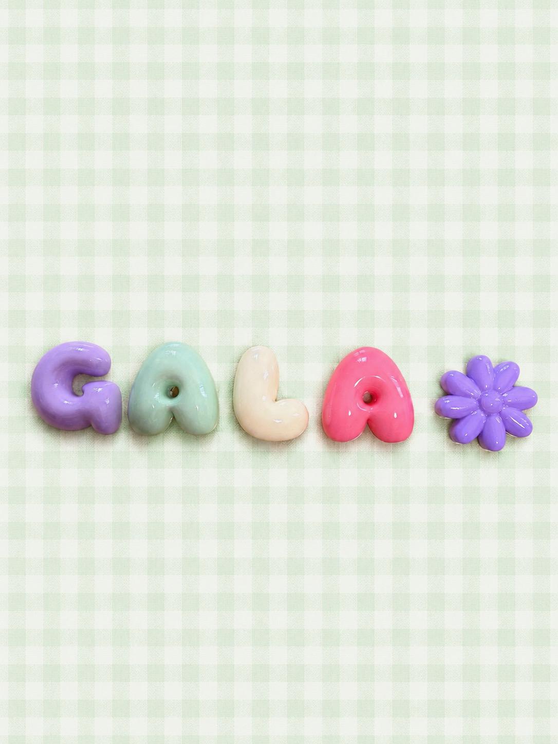 Nombre Gala en letras bubble pastel con una flor lila sobre un mantel de cuadros verde