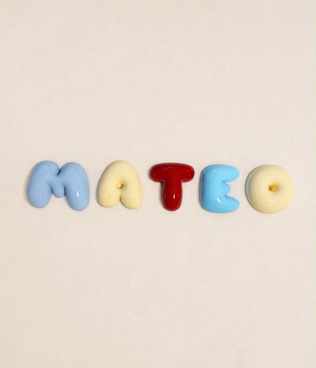 Nombre Mateo en letras bubble azul, beige y granate recién pintadas