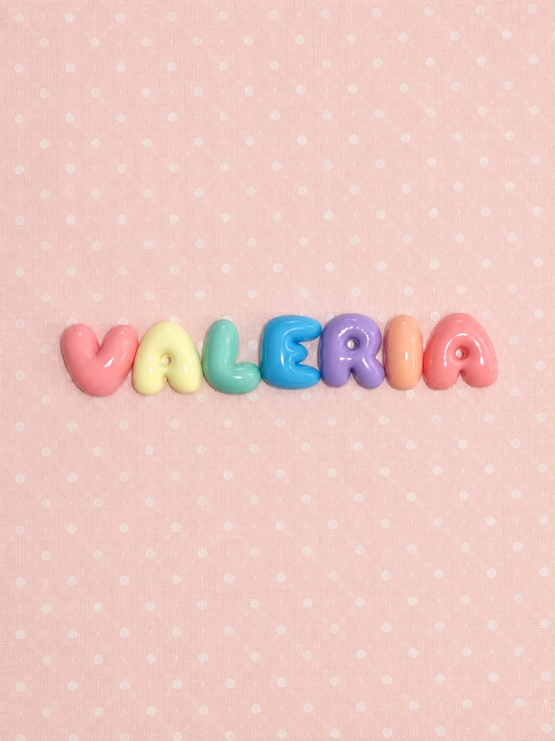 Nombre Valeria en letras bubble arcoíris pastel sobre tela rosa de lunares